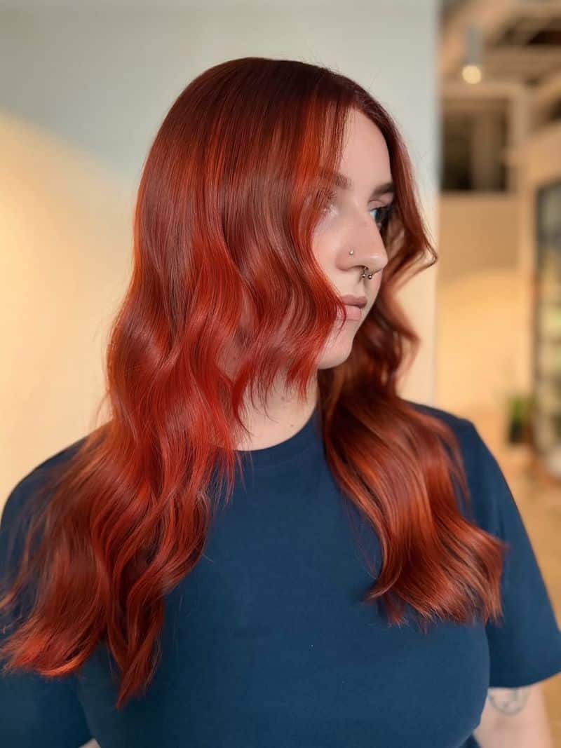 16. Vibrant Auburn Waves with Curtain Bangs