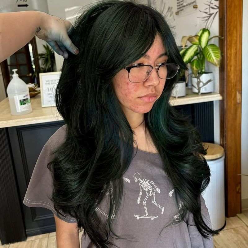 10. Voluminous Emerald Butterfly Cut with Curtain Bangs